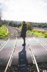 Взрослый мужчина, стоящий на железнодорожном переходе — стоковое фото