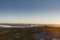 Vista lejana del excursionista corriendo en Laponia, Finlandia - foto de stock