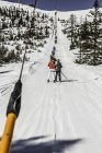 Лыжники на подъемнике, вид сзади — стоковое фото