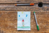 Desenho de crianças de casa com marcadores em mesa de madeira — Fotografia de Stock