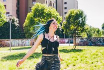 Jovem mulher rindo e correndo no parque urbano — Fotografia de Stock