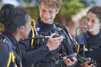 Scuba diving instructor demonstrating oxygen mask to female pupils — Stock Photo