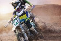 Two young male motocross riders racing on muddy track — Stock Photo