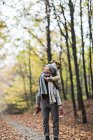 Mãe dando filha piggyback passeio na floresta de outono — Fotografia de Stock