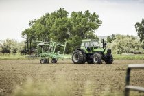 Landwirt fährt mit Traktor und Pflug in Feld — Stockfoto