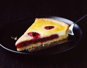 Slice of raspberry and custard tart on plate — Stock Photo