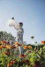 Садовник поливает цветы на открытом воздухе — стоковое фото
