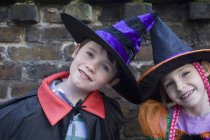 Portrait of boy and girl in Halloween costumes — Stock Photo