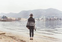 Вид сзади на стильную молодую женщину, выглядывающую со стороны, озеро Комо, Италия — стоковое фото