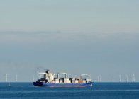 Nave container con parco eolico sullo sfondo — Foto stock