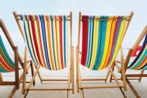 Cadeiras de praia listradas vazias em uma fileira — Fotografia de Stock