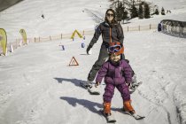 Mãe e filha esquiando juntos, sorrindo — Fotografia de Stock