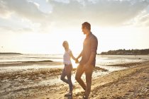 Junges Paar spaziert am sonnigen Strand — Stockfoto