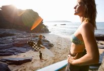 Casal de pé na praia com pranchas de surf — Fotografia de Stock