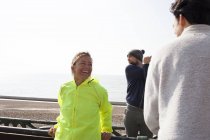 Corredores masculinos e femininos fazendo uma pausa na praia de Brighton — Fotografia de Stock