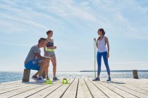 Freunde tragen Sportkleidung auf Pier mit Trainingsgeräten — Stockfoto