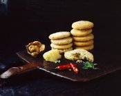 Stacks of homemade walnut chilli cheese oatcakes on vintage wooden tra — Stock Photo