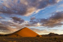 Sonnenaufgang auf Sanddüne mit Wolken darüber, soussvlei, namibia — Stockfoto