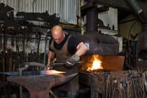 Homme forgeron caucasien au travail en atelier — Photo de stock