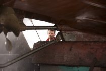 Художник-мужчина использует мойку под давлением для очистки корпуса корабля — стоковое фото