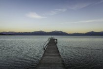 Wooden pier with view of mountains at dusk — Stock Photo