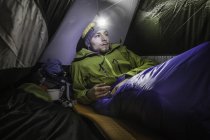 Young male hiker in tent on Klammspitze mountain, Oberammergau, Bavaria, Germany — Stock Photo