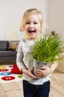 Fille portant une plante en pot — Photo de stock