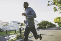 Man in residential area jogging outdoors — Stock Photo
