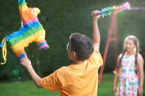 Niños jugando piñata en el jardín - foto de stock