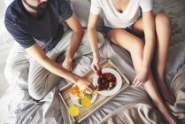 Elevata vista della giovane coppia che fa colazione a letto — Foto stock