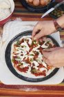 Mani femminili che preparano la pizza sul tavolo da giardino — Foto stock