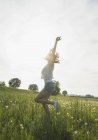 Giovane donna che salta sul campo — Foto stock