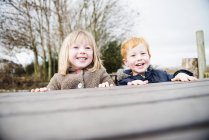 Fratellino e sorella che giocano all'aperto — Foto stock