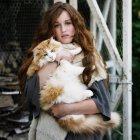 Woman holding large cat outdoors — Stock Photo