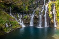 Тропический водопад, текущий над скалами — стоковое фото