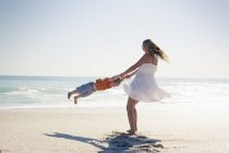 Mãe adulta média balançando filho pequeno por mãos na praia, Cape Town, Western Cape, África do Sul — Fotografia de Stock