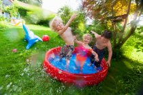 Niños salpicando en la piscina infantil - foto de stock