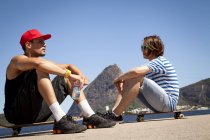 Due uomini seduti su skateboard, rilassanti — Foto stock