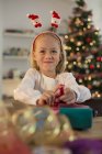 Девочка упаковывает рождественские подарки дома — стоковое фото