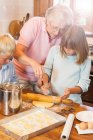 Abuela y nietos haciendo galletas - foto de stock