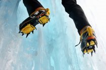 Cropped view of ice climbers feet wearing crampons — Stock Photo