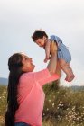 Mother holding baby in midair — Stock Photo