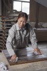 Superficie levigante del falegname della tavola di legno con carta vetrata in fabbrica, Jiangsu, Cina — Foto stock