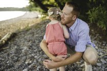 Середині дорослої людини обійматися дочка на озері Онтаріо, Ошава, Сполучені Штати Америки — стокове фото