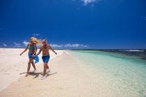 Coppia matura passeggiando lungo la spiaggia, tenendosi per mano, Ile aux Cerfs, Mauritius — Foto stock