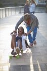 Giovane coppia scherzare su skateboard a riva del fiume — Foto stock