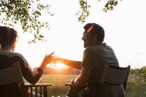 Paar trinkt Wein in Safari-Lodge bei Sonnenuntergang — Stockfoto