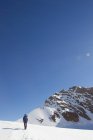 Rear view of man hiking across snow covered landscape, Jungfrauchjoch, Grindelwald, Switzerland — Stock Photo