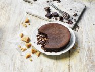 Pudding au caramel au chocolat chaud mangé sur une table désordonnée — Photo de stock