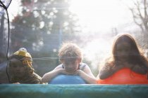 Young children looking out from garden trampoline — Stock Photo